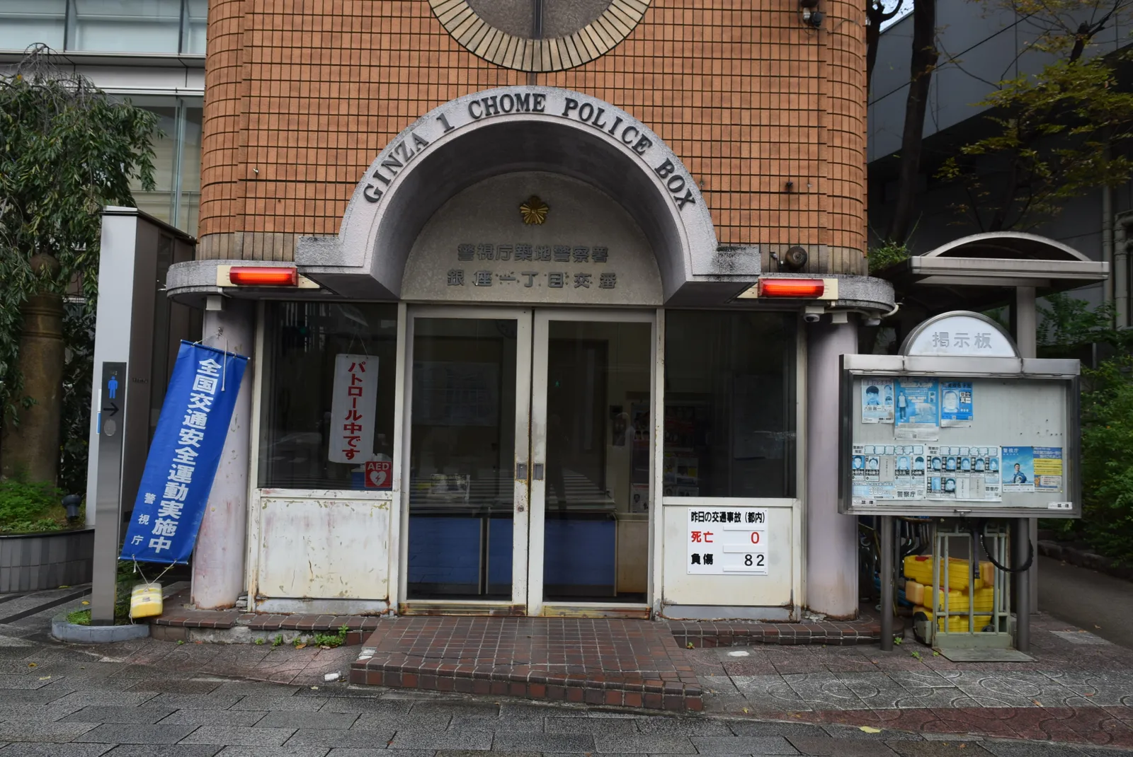 Brick koban police box with arched entrance and a notice board on a street corner in Ginza, Tokyo