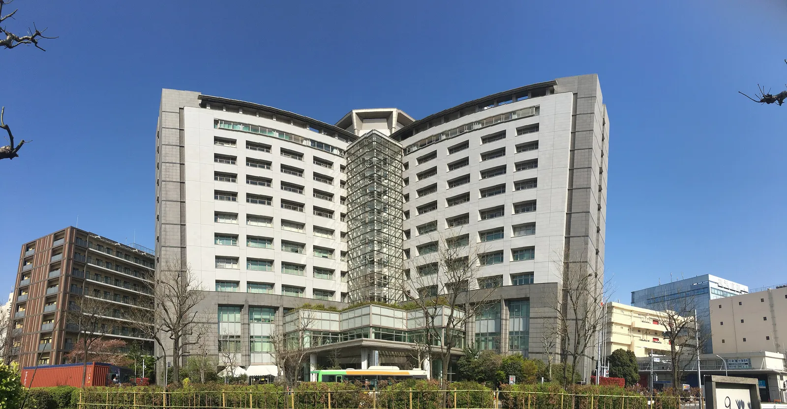 Tall white building of the Tokyo Regional Immigration Services Bureau in Minato, Tokyo, under a clear blue sky