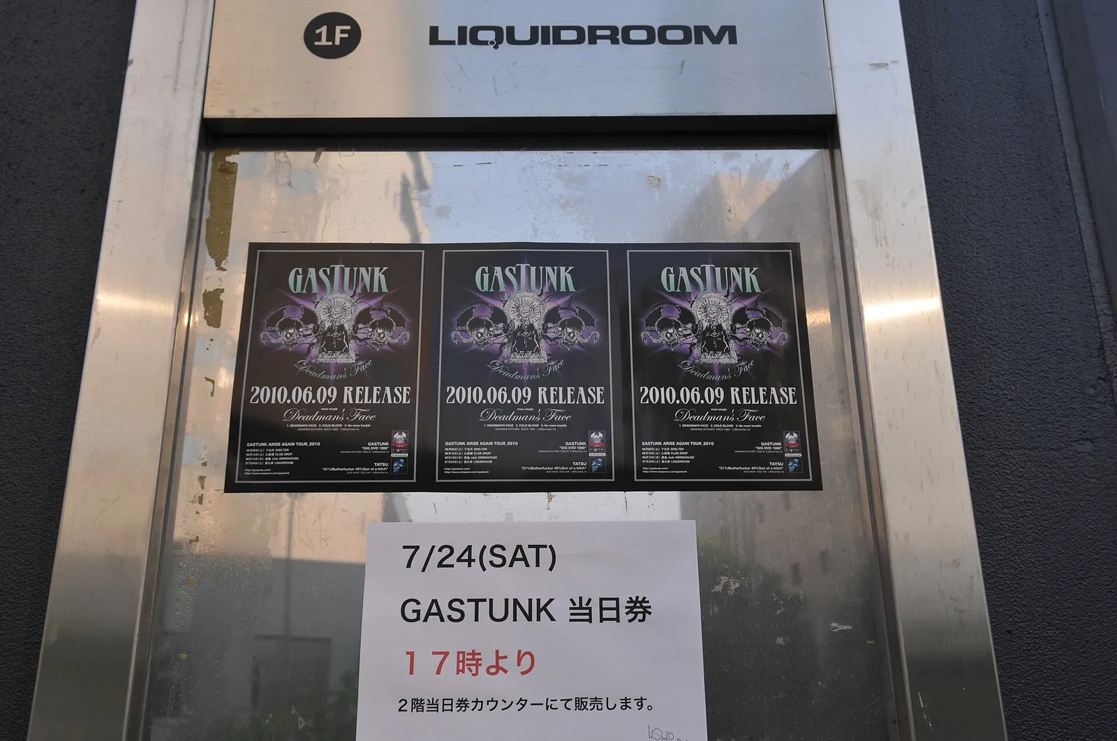 Three band posters and a handwritten notice about same-day tickets taped to the entrance of LIQUIDROOM in Ebisu