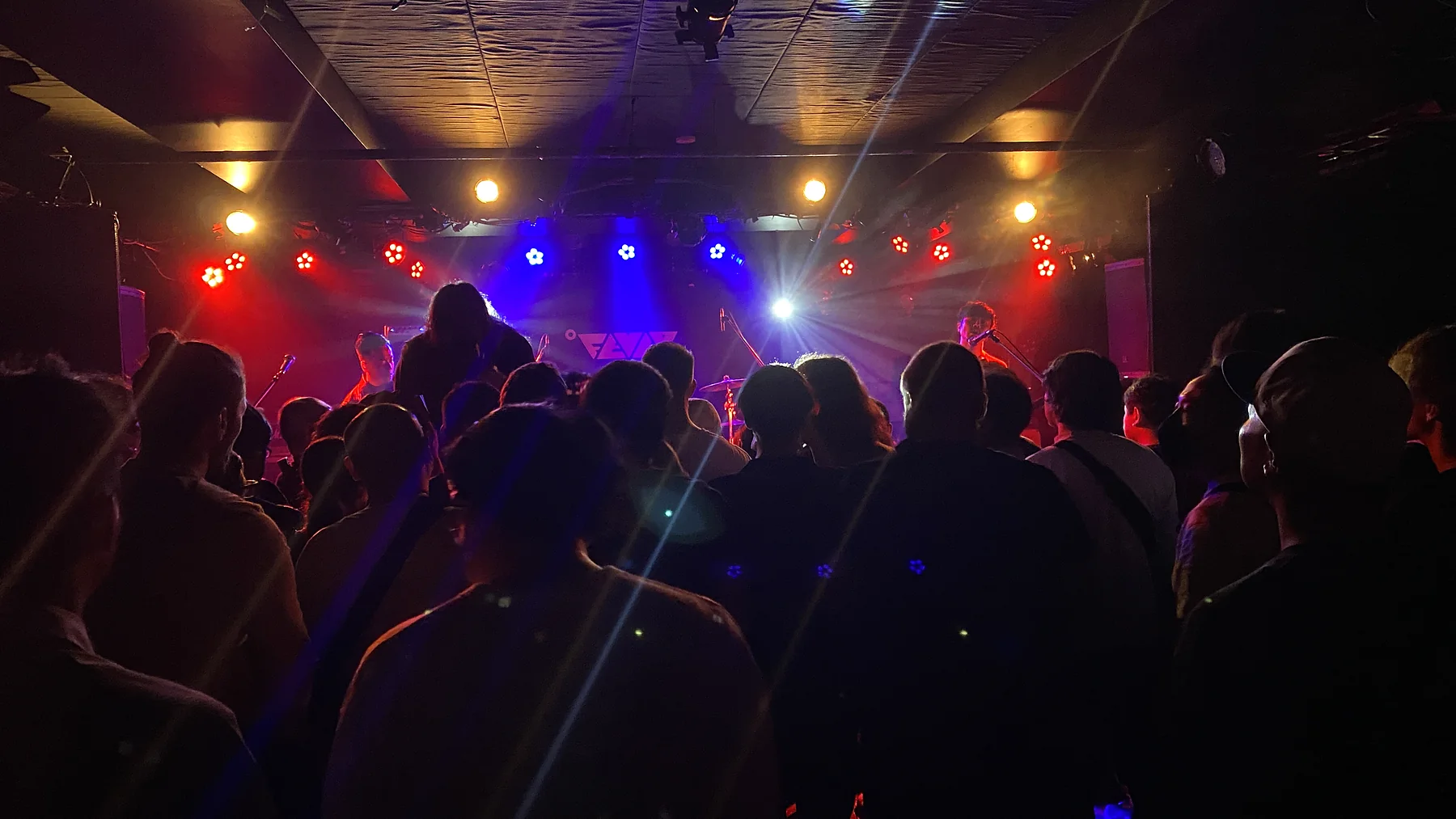 Audience watching a band perform in a small live music venue