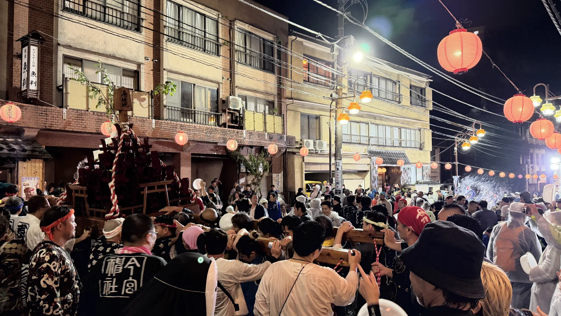 A night festival street in Japan with lanterns and people gathering, used as a visual metaphor for local music discovery